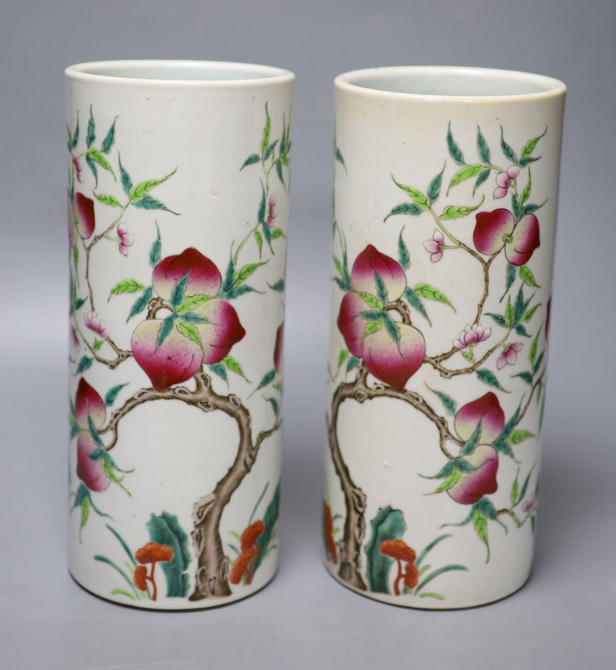 A pair of Chinese famille rose nine peach cylindrical vases, height 28cm